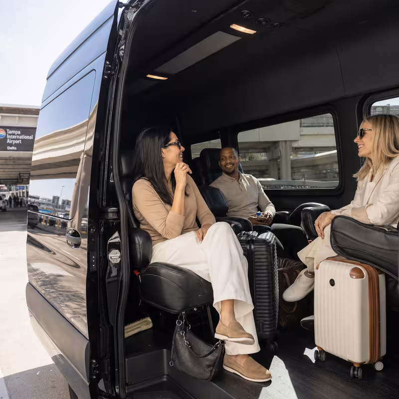 Passengers loading luggage while boarding an Tampa group shuttle
