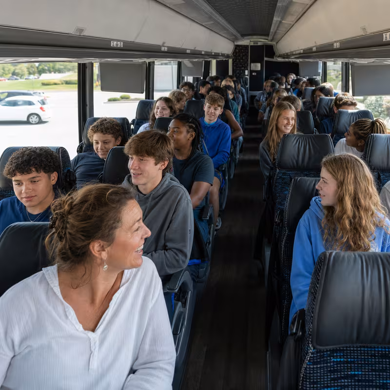 Group boarding a white charter bus for School Transportation transportation in Tampa