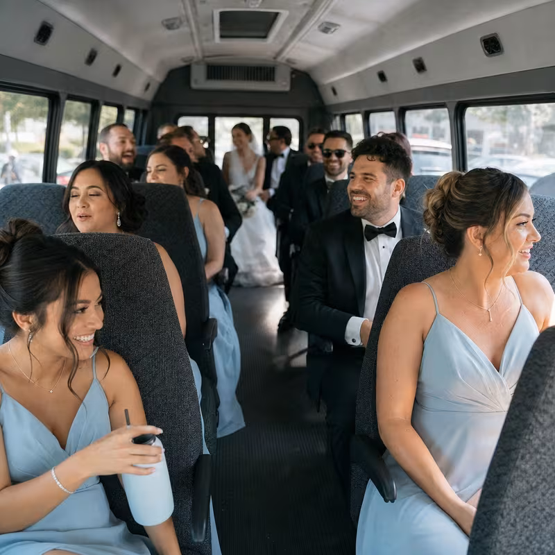 Group boarding a white charter bus for Wedding Transportation transportation in Tampa